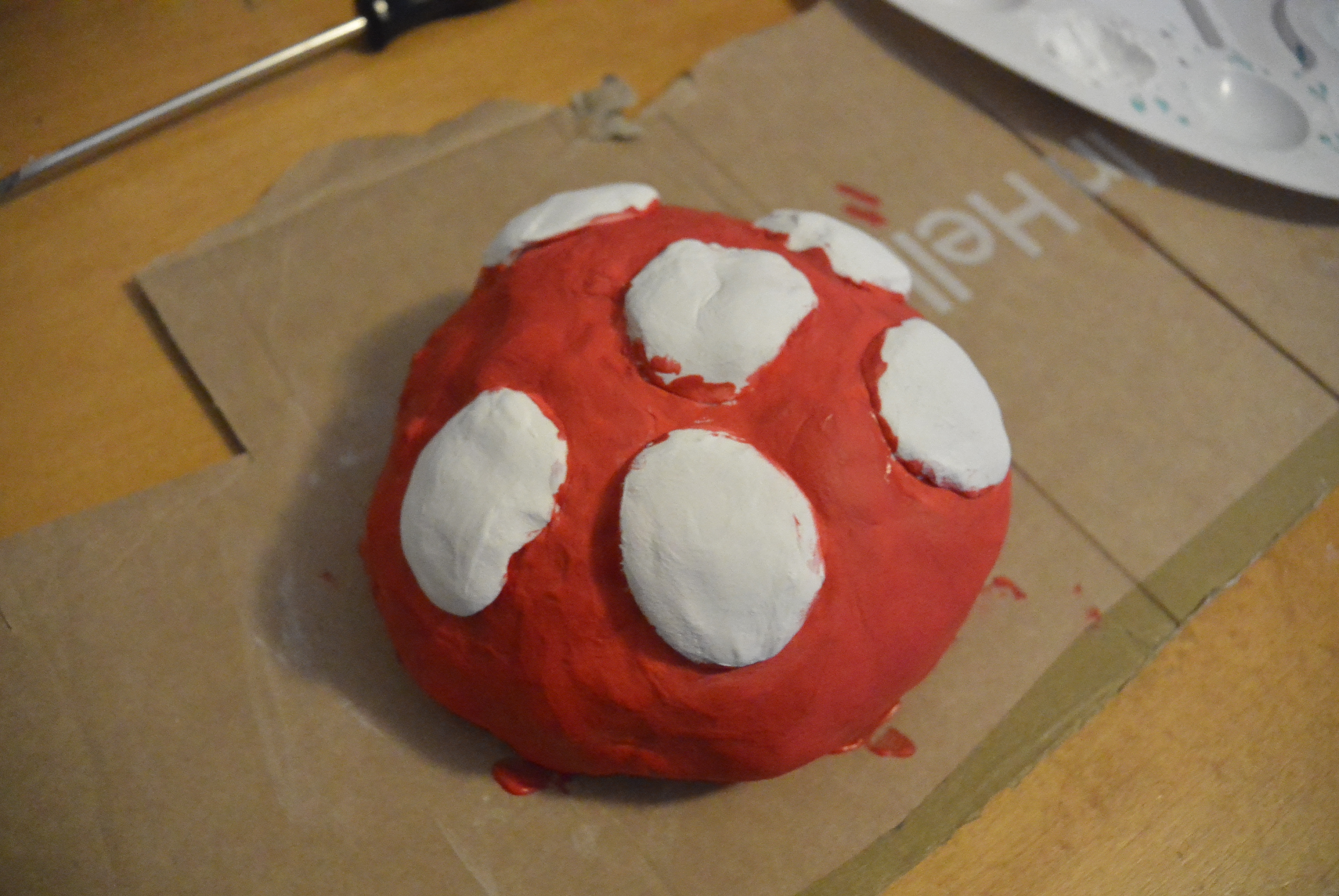 A picture of a painted top part of a mushroom, painted white and red